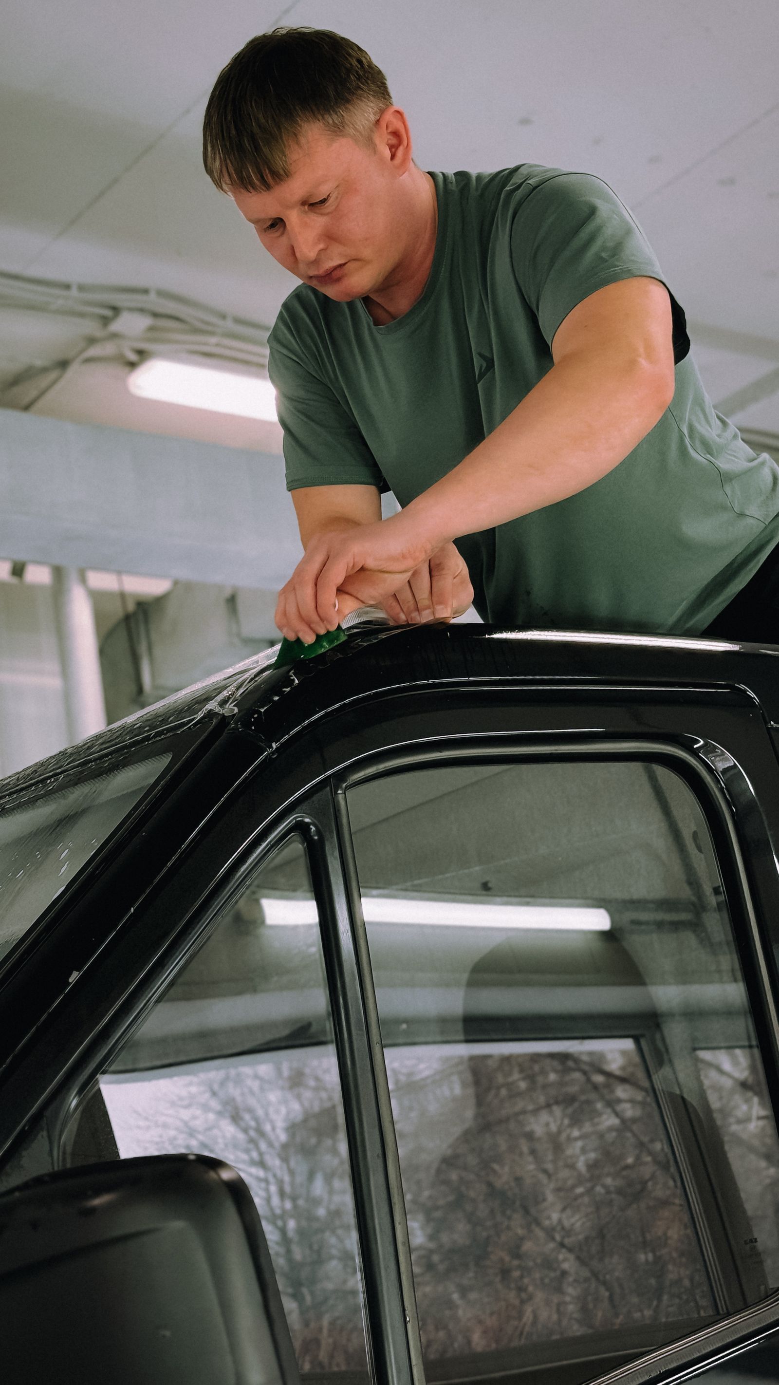 Technician installing automotive window tint film